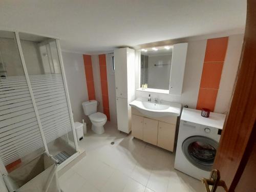 een badkamer met een wastafel en een wasmachine bij ASTERIS HOME in Thérmi