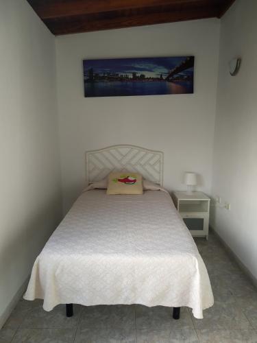 a bedroom with a bed and a painting on the wall at adosado cerca del mar in Playa Honda