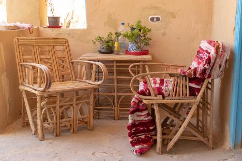 a room with two chairs and a table with plants at Olive Garden House Siwa in Siwa