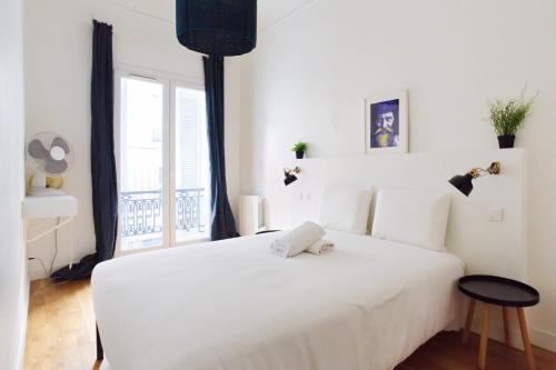 une chambre avec un grand lit blanc avec une fenêtre dans l'établissement Appartement Plumier - Welkeys, à Marseille