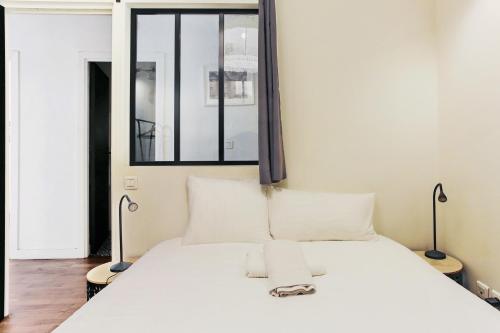 une chambre avec un grand lit blanc avec deux lampes dans l'établissement Appartement Plumier - Welkeys, à Marseille