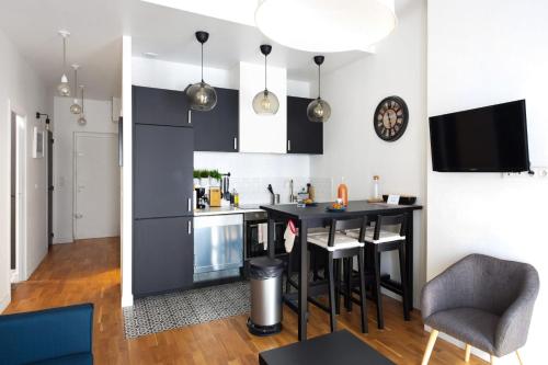 une cuisine et un salon avec une table et des chaises dans l'établissement Appartement Plumier - Welkeys, à Marseille