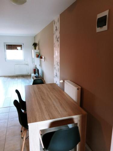 comedor con mesa de madera y sillas en Liliána Apartman, en Cserkeszőlő