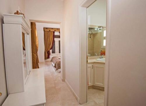 a white bathroom with a bed and a mirror at Y 140 wast golf heated private pool in Hurghada