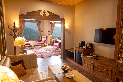 a living room with a couch and a television at Skyview by Empyrean in Patnitop