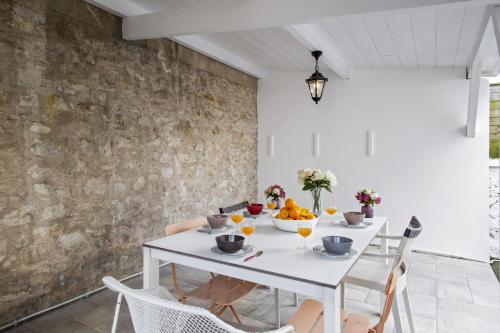 une salle à manger avec une table et des chaises blanches dans l'établissement Appartement du Chêne - Welkeys, à Biarritz