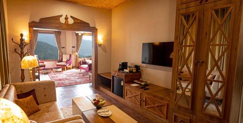 a living room with a large wooden door and a living room with a couch at Skyview by Empyrean in Patnitop