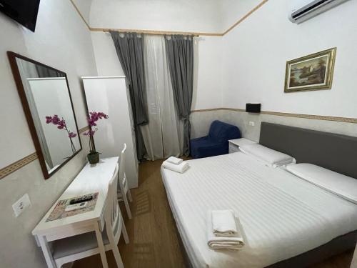 a small room with a bed and a table with flowers at Conte House merulana guesthouse in Rome