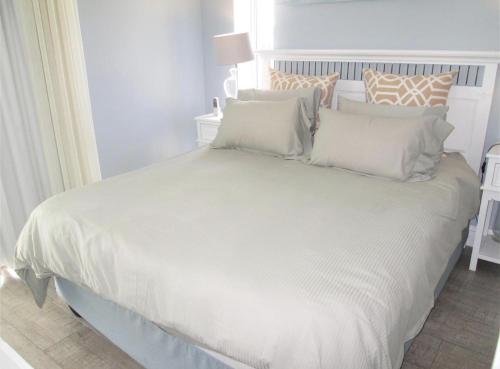 a white bed with white sheets and pillows at Seabreeze At 301 in Ballito