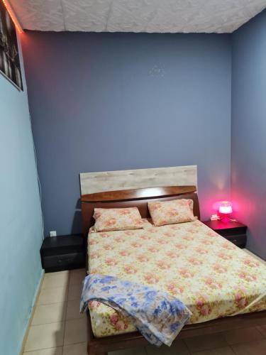 - une chambre avec un lit et un mur bleu dans l'établissement vacation house יחידת אירוח פרטית הוד השרון, à Hod HaSharon