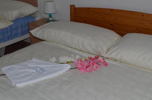 a bed with two white towels and flowers on it at Hotel San Giobbe in Giubiasco