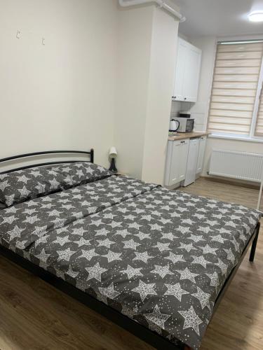 Cette chambre comprend un grand lit et une cuisine. dans l'établissement 0263-1 Смарт-апартаменты ЖК «Счастливый», à Kiev