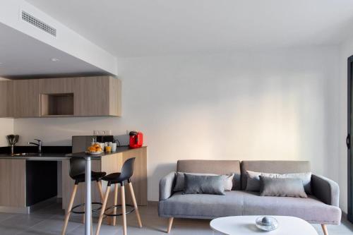 un salon avec un canapé et une table dans l'établissement Appartement Maréchal - Welkeys, à Cannes