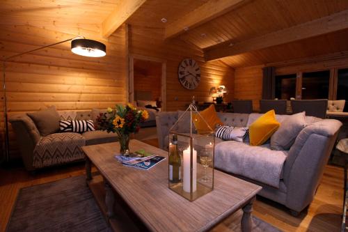 a living room with a couch and a table at Cambridgeshire Lakes - luxury lodges in a stunning lake location in Gamlingay