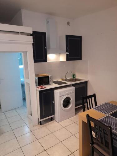 une cuisine avec un évier et une machine à laver dans l'établissement STUDIO ROUGE à 5 minutes de la Cathédrale et Néoma, à Reims
