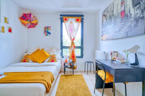 a bedroom with a bed and a desk and a window at Chambres d'hôtes de Luxe Ma Suk in Saint-Denis