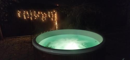 a bath tub with lights in it in the dark at Villa del Grossa Будинок з каміном та чаном на дровах in Kuchakiv
