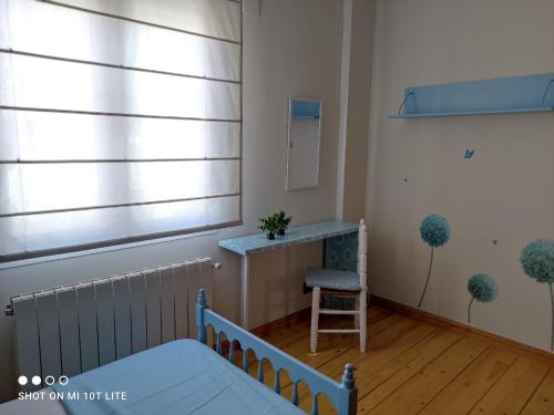 a bedroom with a bed and a table and a chair at Rucanon 1 La casa del pueblo 4 Estrellas in Montánchez