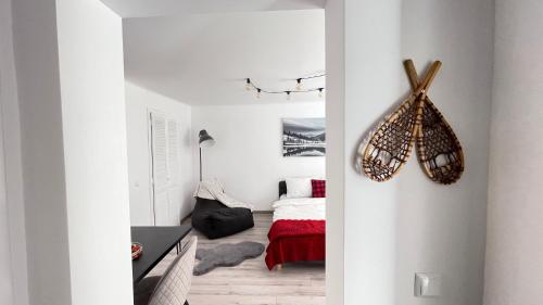 biały pokój z sypialnią z łóżkiem w obiekcie Maple Lodge Apartments w Braszowie