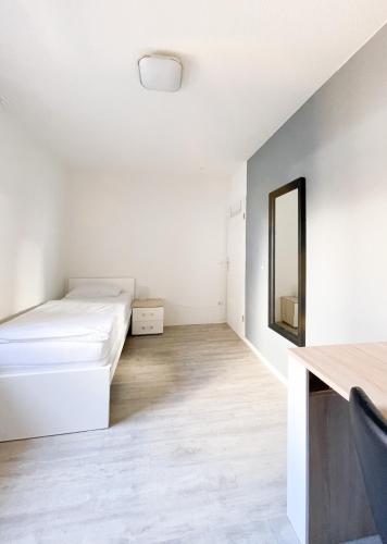 a white room with a bed and a mirror at Traumhaftes Privatzimmer in Karlsruhe in Karlsruhe