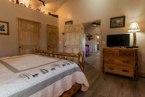 a bedroom with a bed and a flat screen tv at Calhoun House Inn & Suites in Bryson City