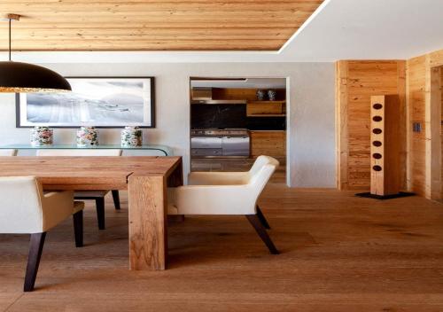 a dining room with a wooden table and white chairs at Regent Retreat by MC in Rougemont