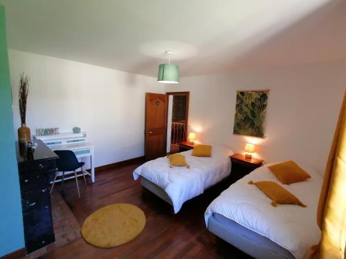 een hotelkamer met 2 bedden en een bureau bij Gite charm'en Vexin in Neuilly-en-Vexin