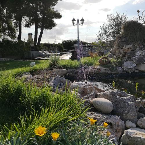 a garden with a pond and a fountain at Aura Solis B&B in Leuca