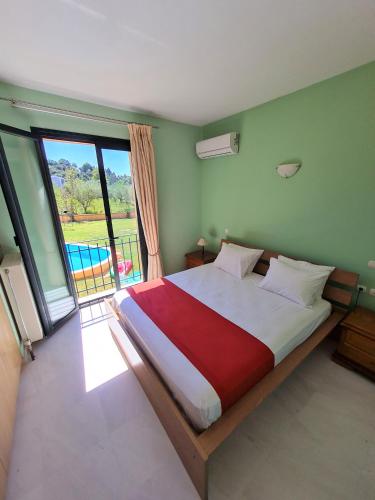 a bedroom with a large bed with a large window at Casa Spannika Pool And Gym in Zakynthos