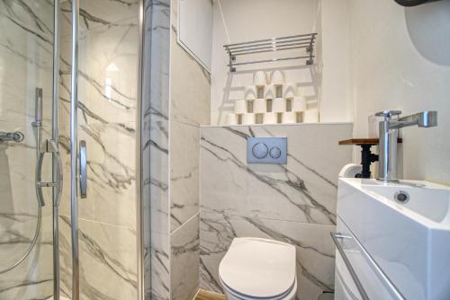 a bathroom with a shower and a toilet and a sink at Superbe 3 pièces refait à neuf classé 4 étoiles avec ascenseur et balcon à pied de la plage et du palais des festivals in Cannes