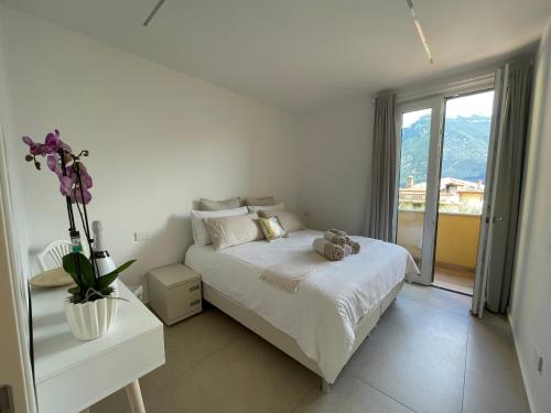 a white bedroom with a bed and a window at B&B Am Gardasee blick in Limone sul Garda