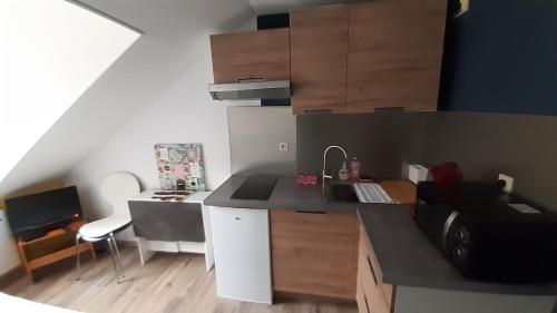 une petite cuisine avec un évier et un micro-ondes dans l'établissement Studio 402 au 15 rue Battant à Besançon, à Besançon