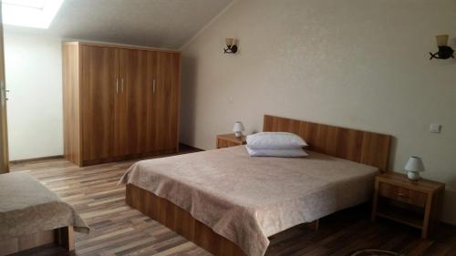 1 dormitorio con 1 cama y armario de madera en Zodiac en Caransebeş
