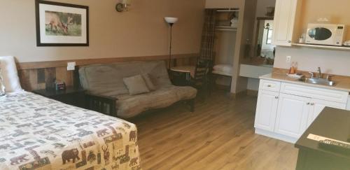1 dormitorio con cama, sofá y cocina en Jasper Gates Resort, en Jasper
