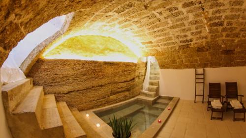 Habitación con piscina en una pared de piedra. en CORTE LARGO LAURO DIMORE & SPA en Gemini