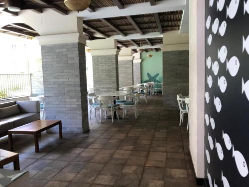 a room with tables and chairs in a restaurant at Tata Housing -Garden & pool view-6KM from Airport in Marmagao
