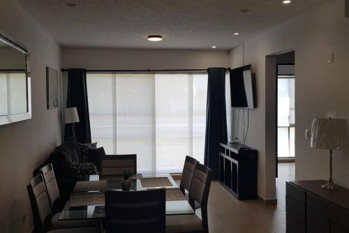 a dining room with a table and chairs and a window at Increible Apartment with beach Monterrey/Apodaca in Monterrey