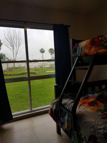 a bedroom with a window with a view of a field at Increible Apartment with beach Monterrey/Apodaca in Monterrey