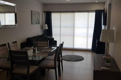 a dining room with a table and chairs and a living room at Increible Apartment with beach Monterrey/Apodaca in Monterrey
