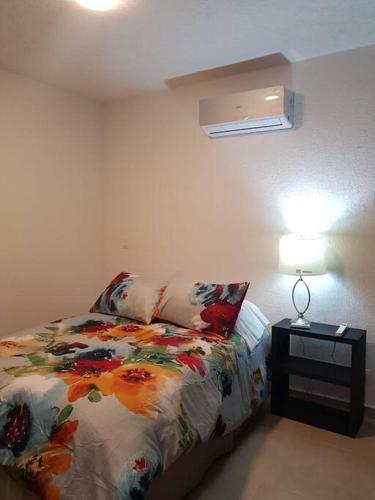 a bedroom with a bed and a lamp on a table at Increible Apartment with beach Monterrey/Apodaca in Monterrey