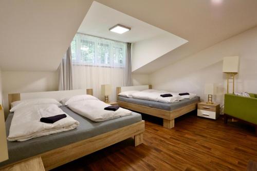 a bedroom with two beds and a window at Pension Lesná in Jiřetín pod Jedlovou