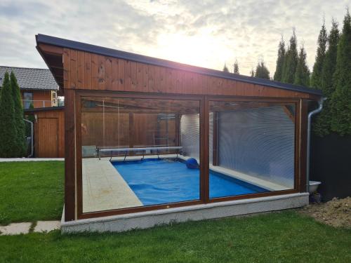 una pequeña piscina en una casa con una gran ventana en Vila MAX - BAZÉN & SAUNA, en Velké Losiny