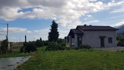 a small house in a green field next to a building at Lithos Villas in Amfiklia