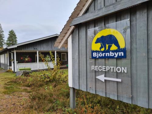 a sign on the side of a building with a bear at Björnbyn Stugby in Råda