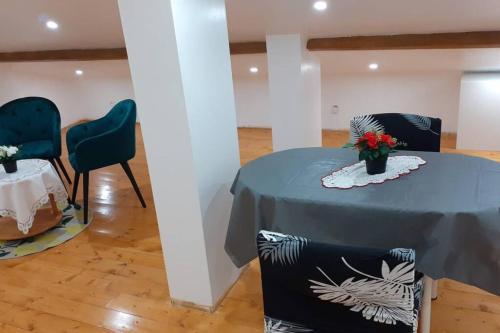 a table with two chairs and a table with flowers on it at Appartement La JOIE dans quartier chic in Pibrac