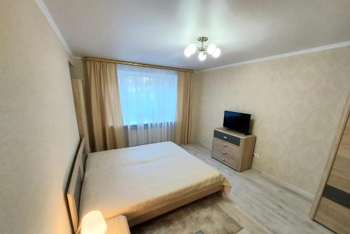 a small bedroom with a bed and a television at Апартаменты возле Зоопарка in Kaliningrad