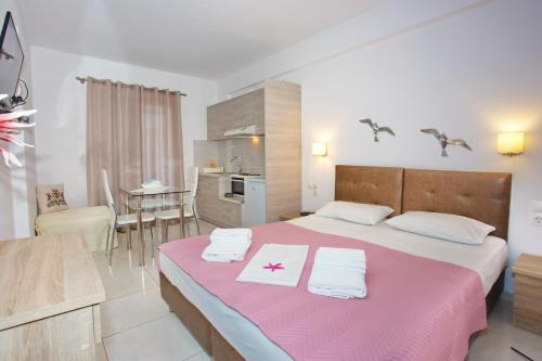 a bedroom with a large bed with towels on it at Aspous Studios and Rooms in Skiros