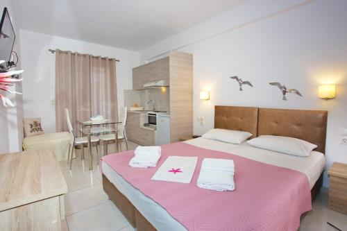 a bedroom with a large bed with towels on it at Aspous Studios and Rooms in Skiros