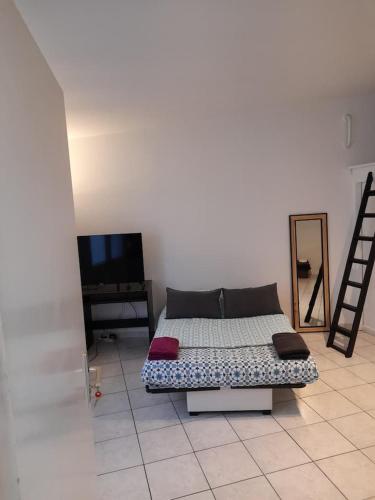 - un canapé installé sur un sol carrelé dans l'établissement STUDIO ROUGE à 5 minutes de la Cathédrale et Néoma, à Reims