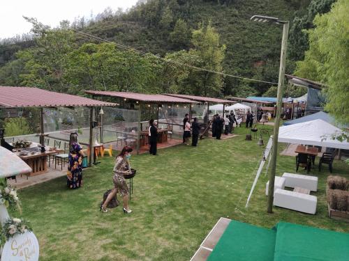a group of people walking around in a field at Hotel Cabañas El Rincón de las Campanas in Nobsa